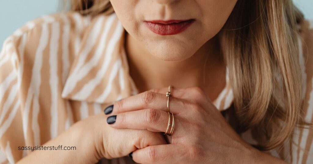 close-up of midlife woman in deep thought with her hands clasped under her chin.