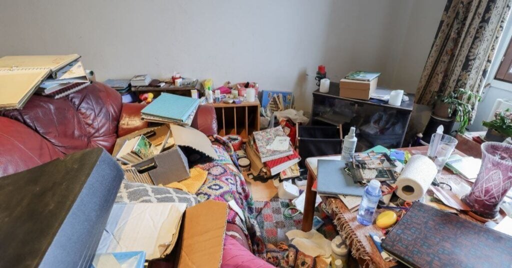 messy room in a home with trash and clutter thrown everywhere showing red flags that point to hoarding behavior.
