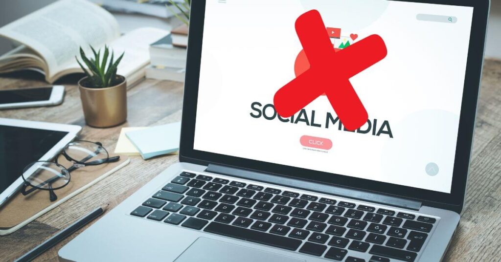 laptop with big red X over the words social media.