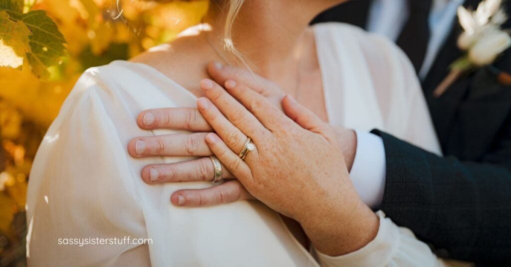 a close-up of an older bride and groom hugging with their rings showing.