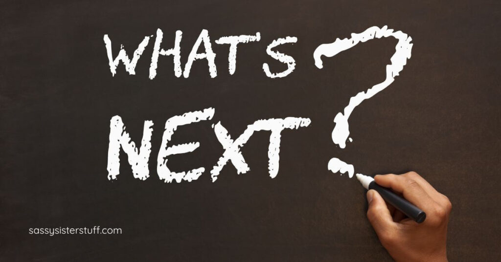 female hand writing What's Next? on the chalkboard.