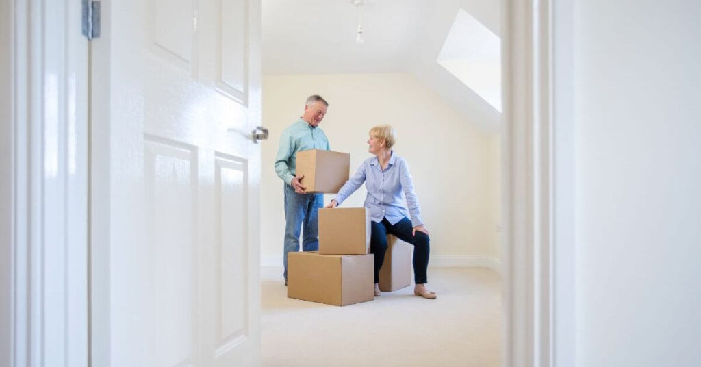 couple packing boxes in a room they plan to repurpose after adult kids moved out.