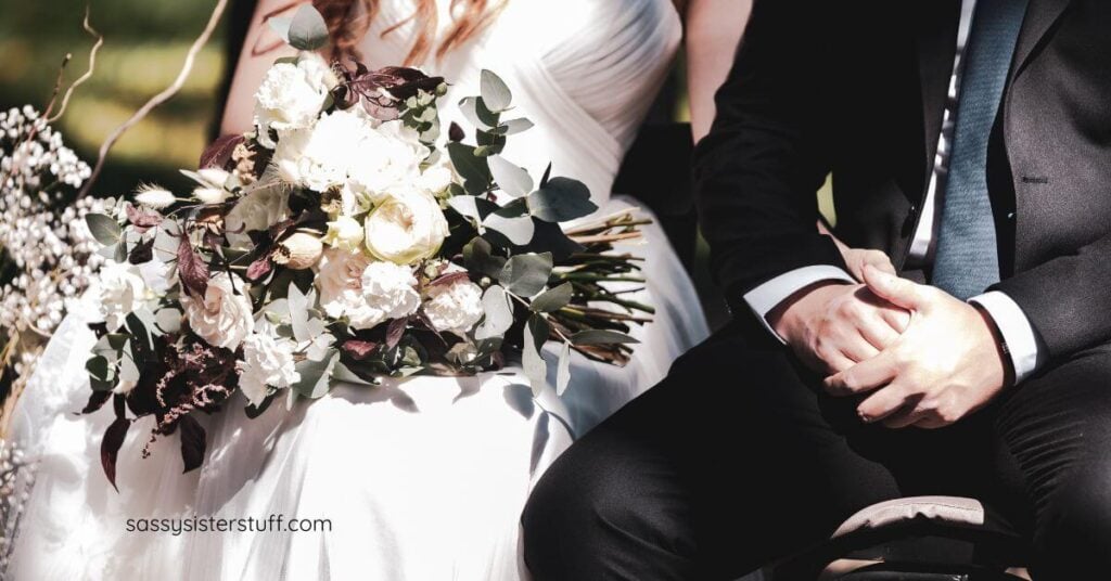 close-up of bride and groom with a bouquet in the bride's lap.