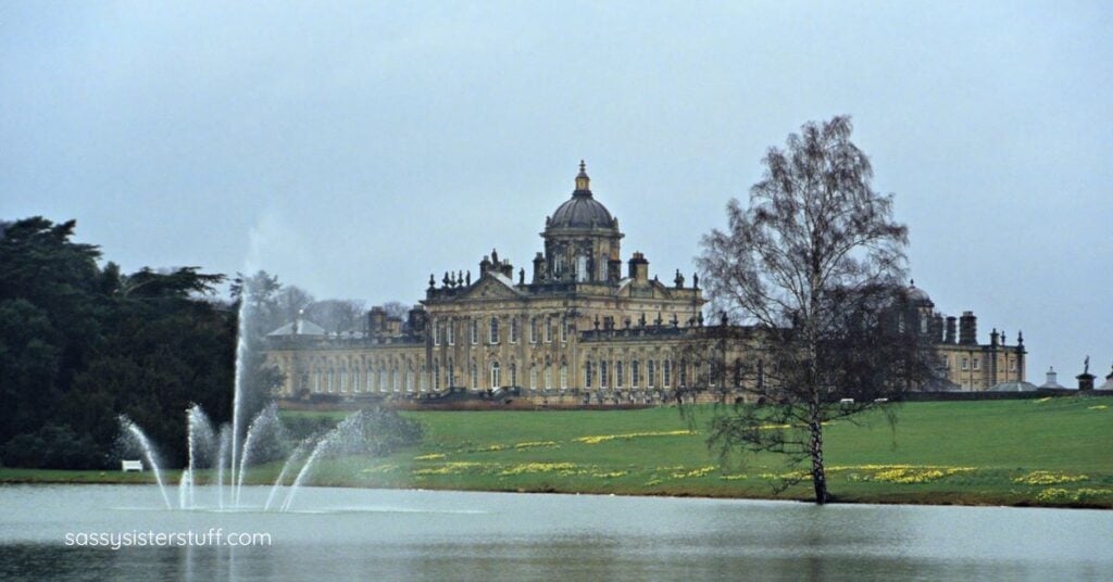 a large mausoleum sitting on the hillside of a cemetery next to a lake.