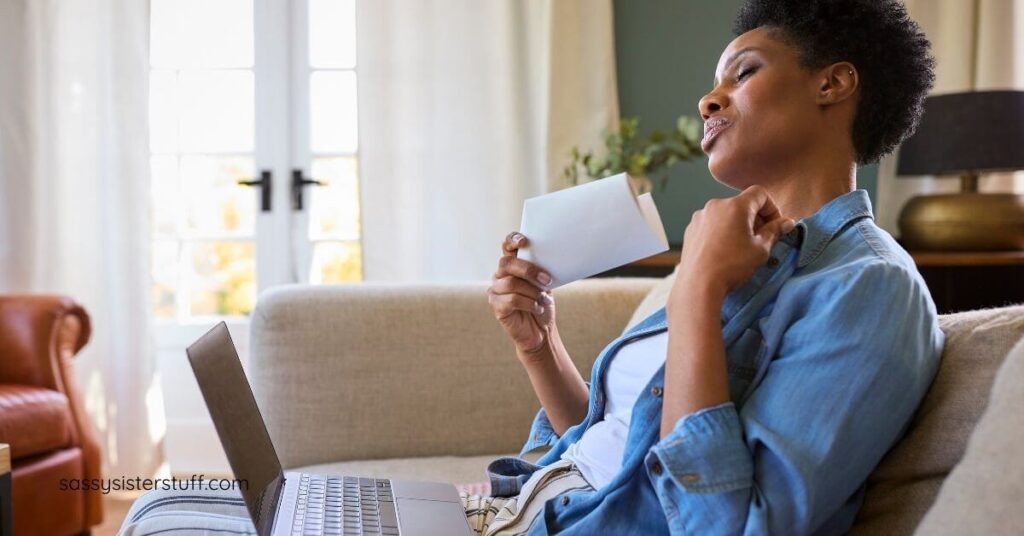 middle aged woman sitting on her sofa fanning herself because of hot flashes thinking about what she needs to do for the brain remodel in this stage of life.