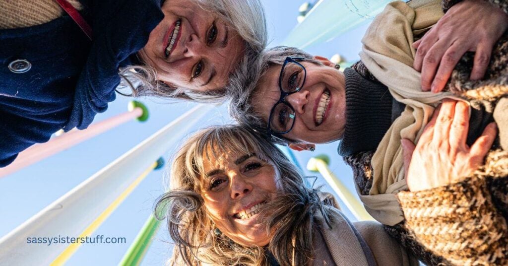 three silly midlife women looking down over a camera on the ground to add adventure to everyday life.