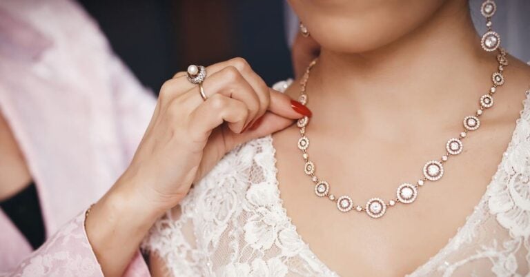 mother helping her daughter put on family heirloom jewelry on her wedding day.