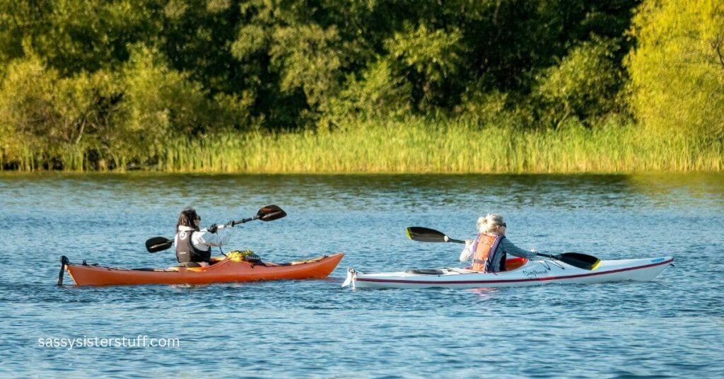 two ladies canoe in a lake for the many benefits of adventures in midlife.