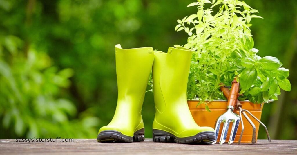 close-up of green rain boots and garden tools sitting on a deck.