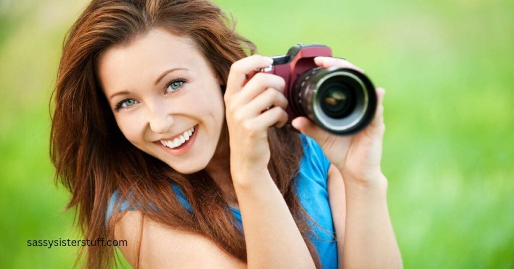 beautiful, happy woman with a camera poses for a picture from behind the camera.
