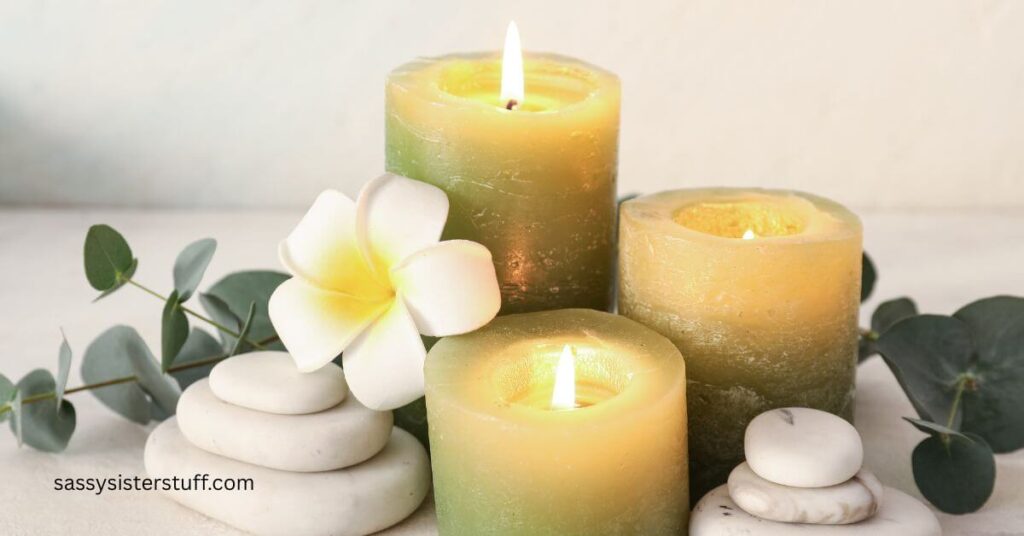 close up of candles, balance stones, euclyptus, and an orchid grouped together nicely to represent self-care and a mental reset.