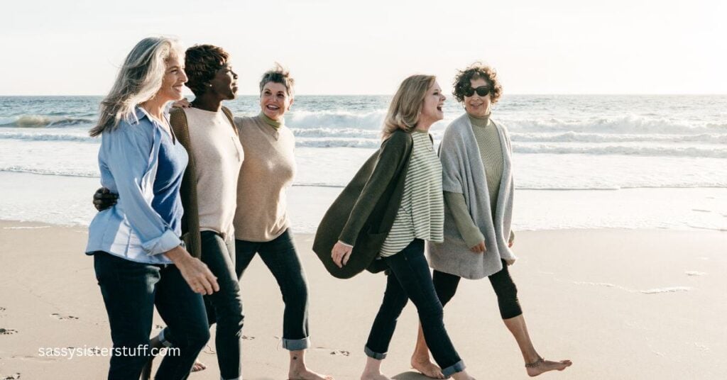 five midlife women walk along the beach together because aging changes the way we celebrate big moments and they planned a quiet weekend getaway.