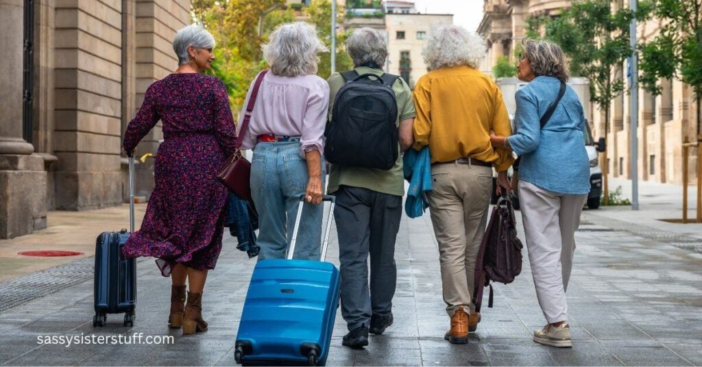 five midlife women walk down the street with carry on suitcases they brought on a weekend getaway.