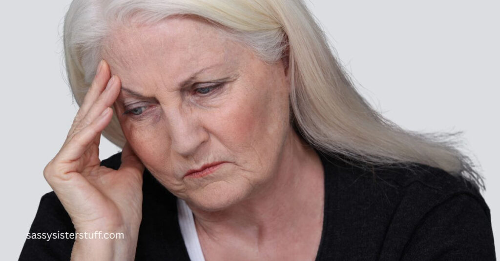 a woman holds her head because she has a migraine and she considers a biopsychosocial approach to pain management.