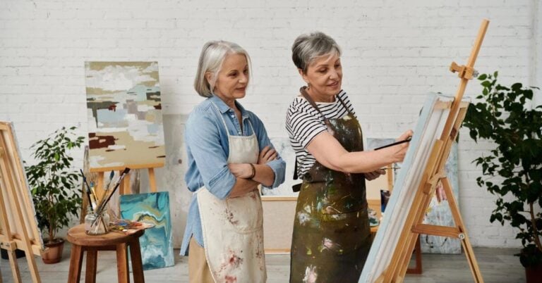 two middle age women in a hobby room painting.