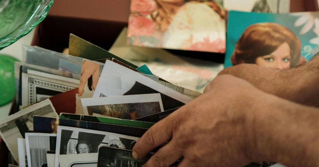 close up of hands sorting through old pictures in a box
