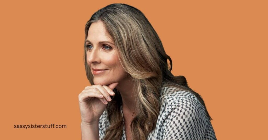 a close up of a middle aged woman smiling and reflecting on what finding yourself again in midlife means.
