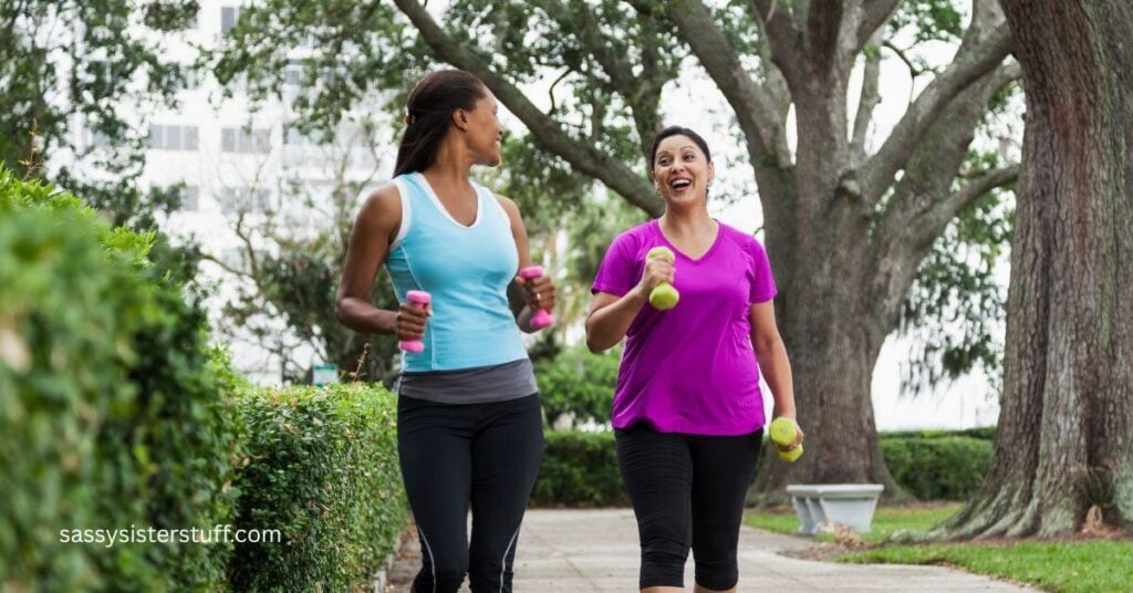 two new midlife friends power walk together though the park.