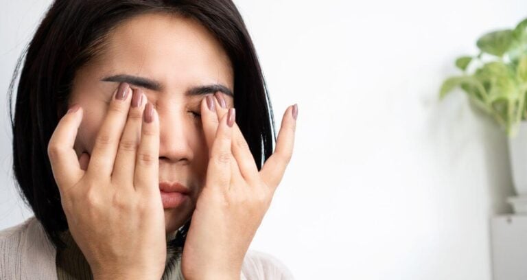 woman rubbing her eyes in frustration because she needs to learn how to stop taking things personally.