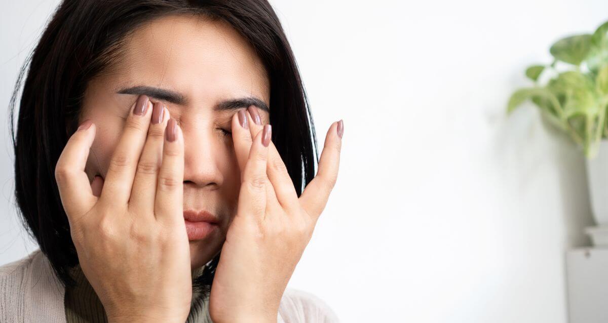 woman rubbing her eyes in frustration because she needs to learn how to stop taking things personally.