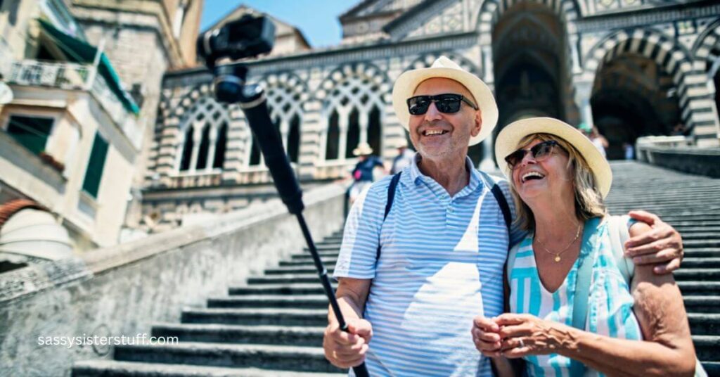 a couple who are traveling after 50 stand on the steps of a temple and take a selfie.