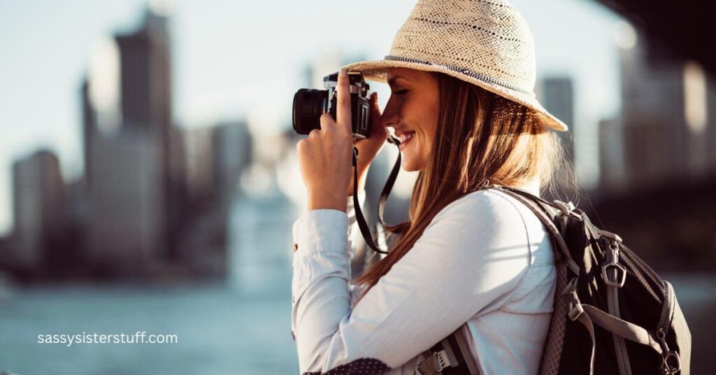 a woman traveling after 50 takes a picture of a city skyline.