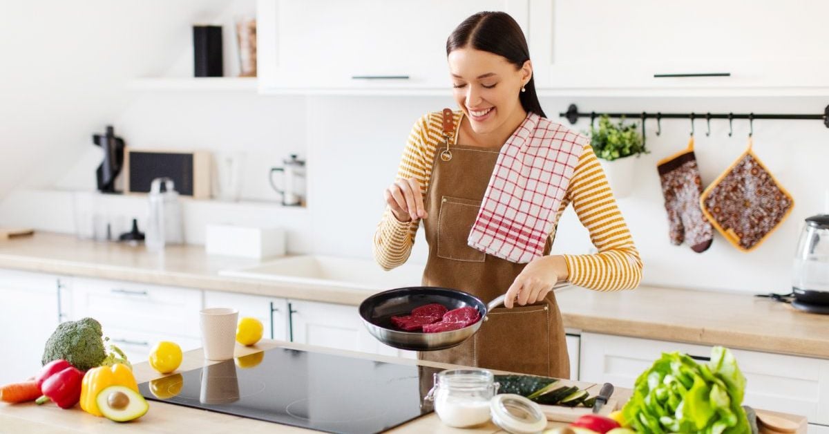 happy woman starting a new hobby, cooking in the kitchen.
