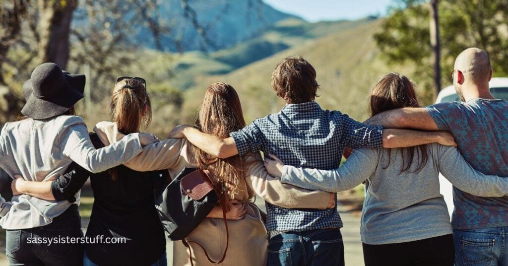 six people standing with their arms around each other looking off into the mountains to show they understand social wellness and why it is important.