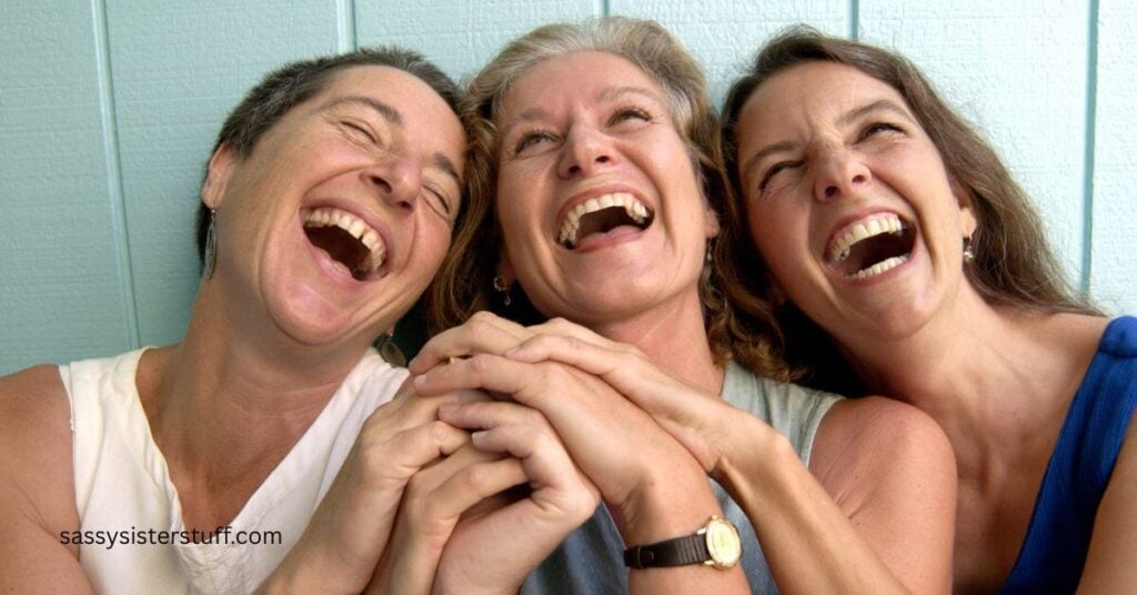 three midlife women laughing hysterically together demonstrating social wellness and why it is important.