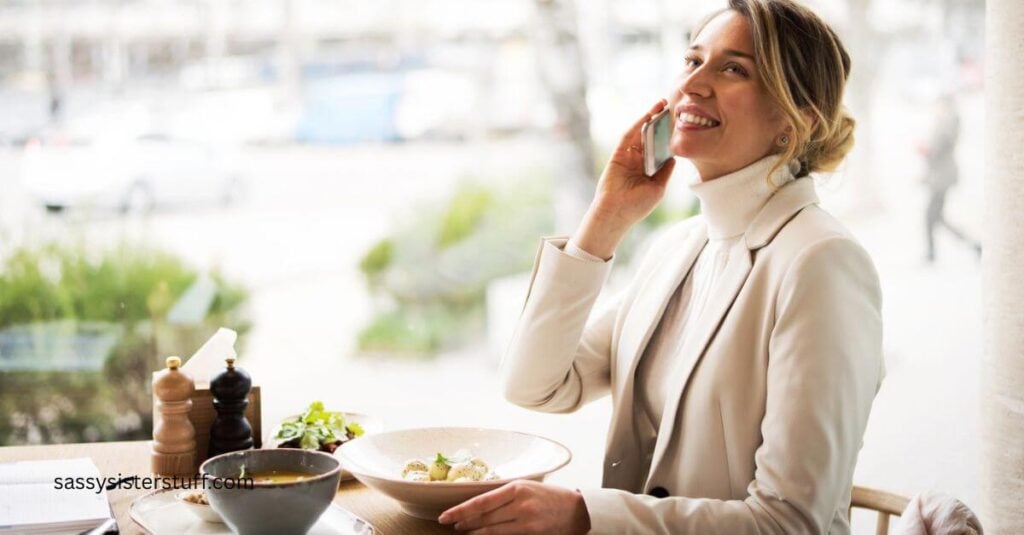 businedd woman dining alone on a salad while talking on the phone.