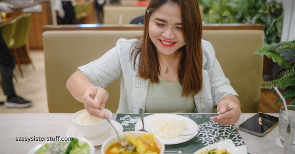 middle aged Asian woman dining alone on a emal of Asian food.