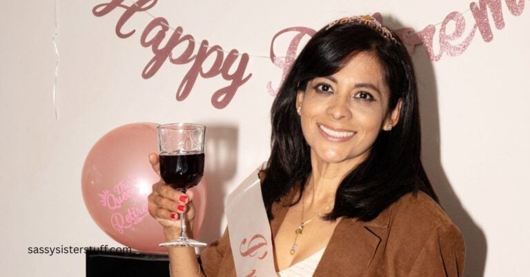 a beautiful woman raises a glass and poses for a photo in front of her happy retirement sign,